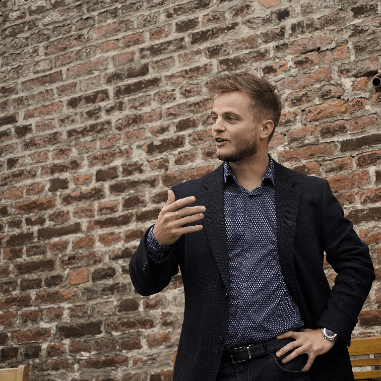 David Prochazka stojí před cihlovou zdí